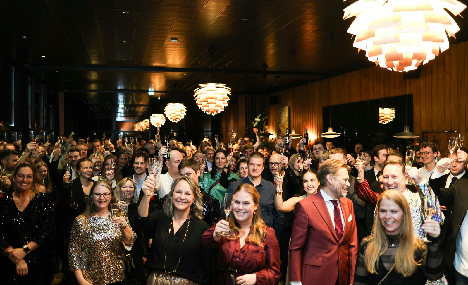A room of guests raising a toast at a company gala